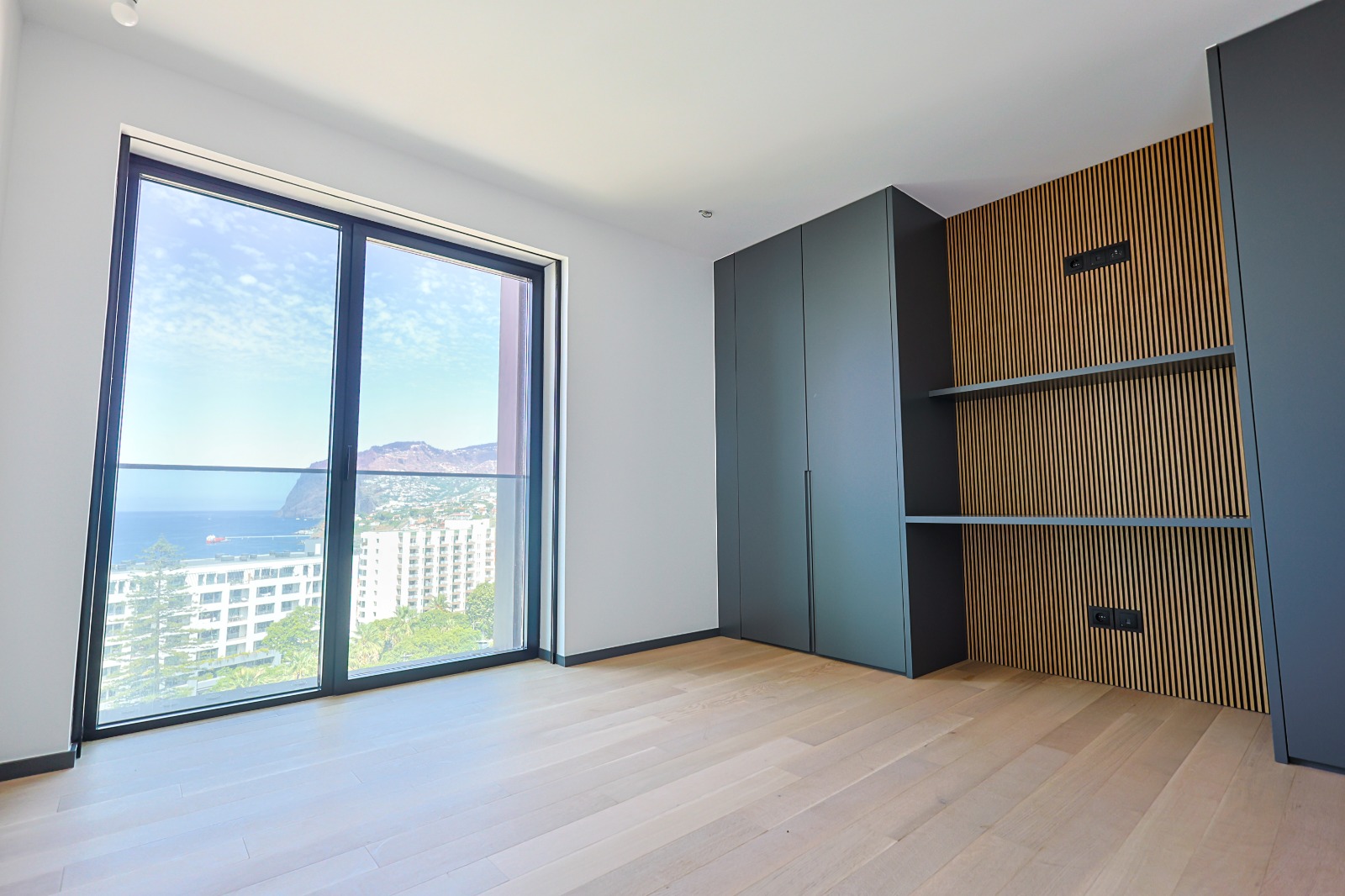 Bedroom with fitted wardrobes, oak-slat panelling and full-height window, Varino 07, Funchal