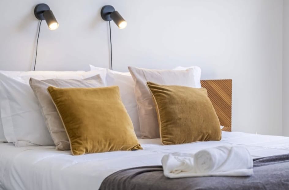 Doppelbett mit Wandleseleuchten und Kopfteil aus Holzlamellen, Penthouse in São Martinho, Funchal