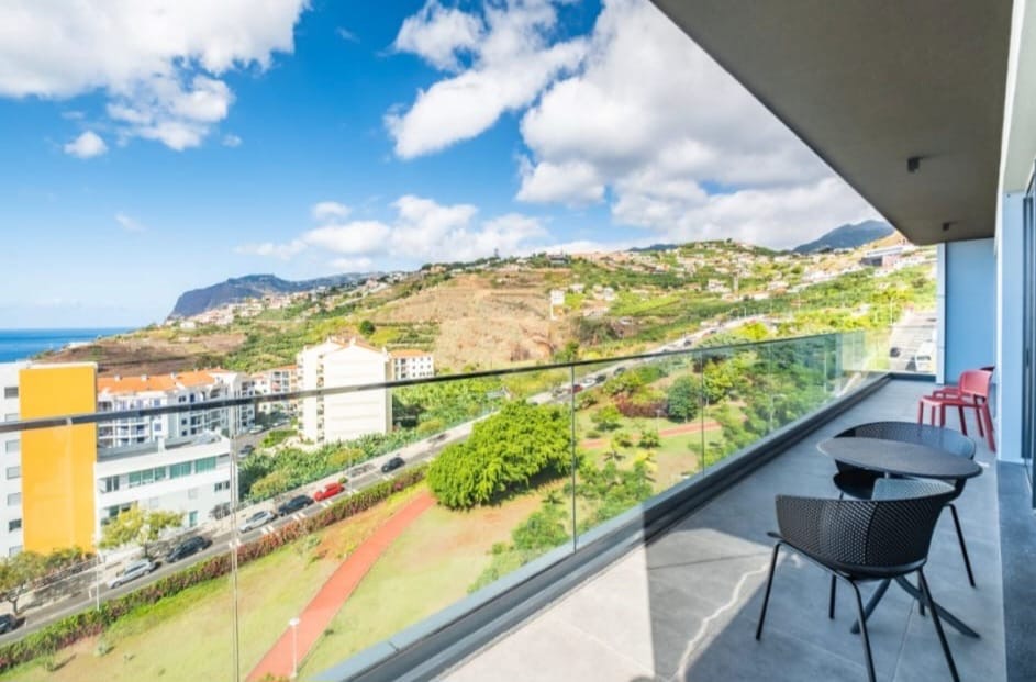 Überdachter Balkon mit Sitzplatz und Blick über Küste und Hänge von São Martinho, Funchal