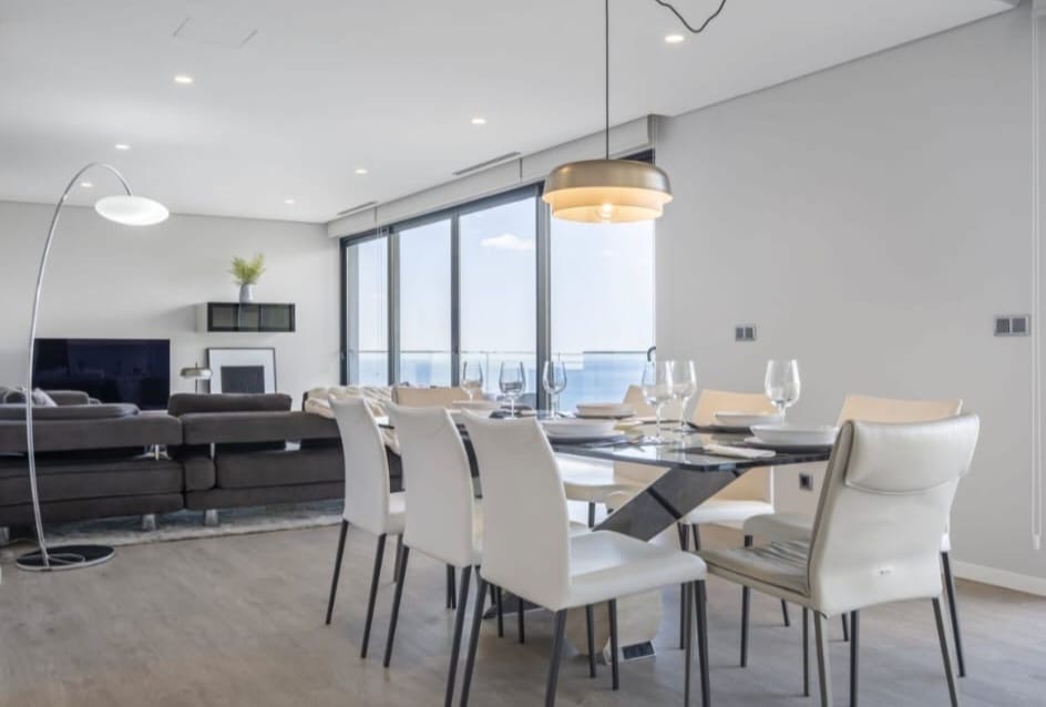 Wohn- und Essbereich mit Meerblick durch raumhohe Schiebefenster, Penthouse in São Martinho, Funchal