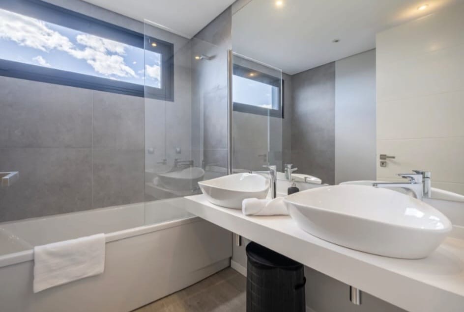 Badezimmer mit zwei Aufsatzwaschbecken, Badewanne und ebenerdiger Dusche, Penthouse in São Martinho, Funchal